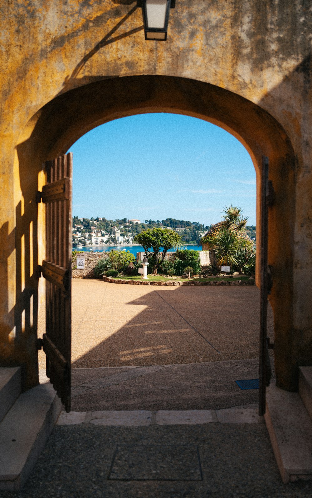 an open door leading to a walkway with a view of a harbor
