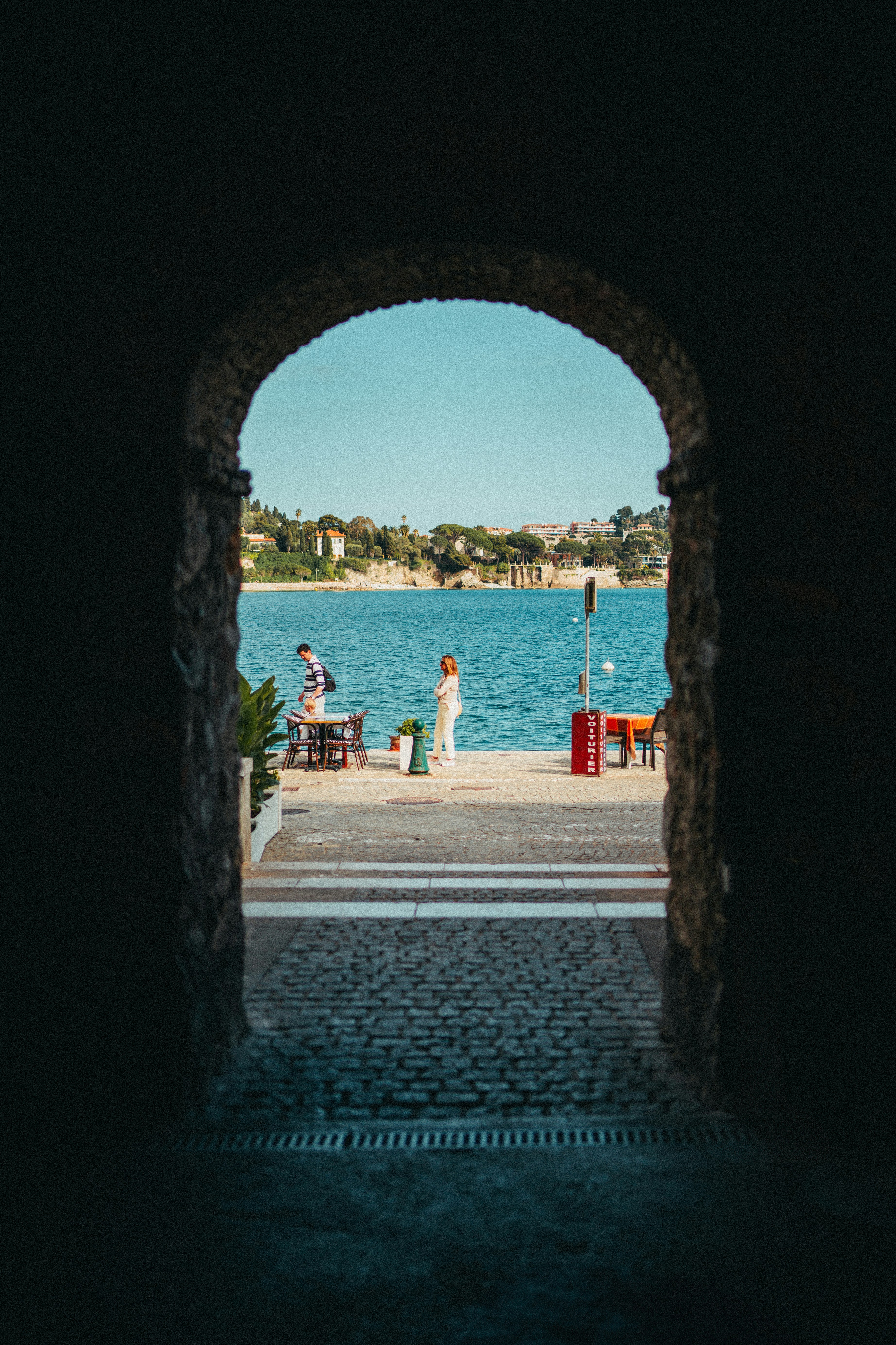 a couple of people that are standing in front of a body of water