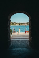 a couple of people that are standing in front of a body of water