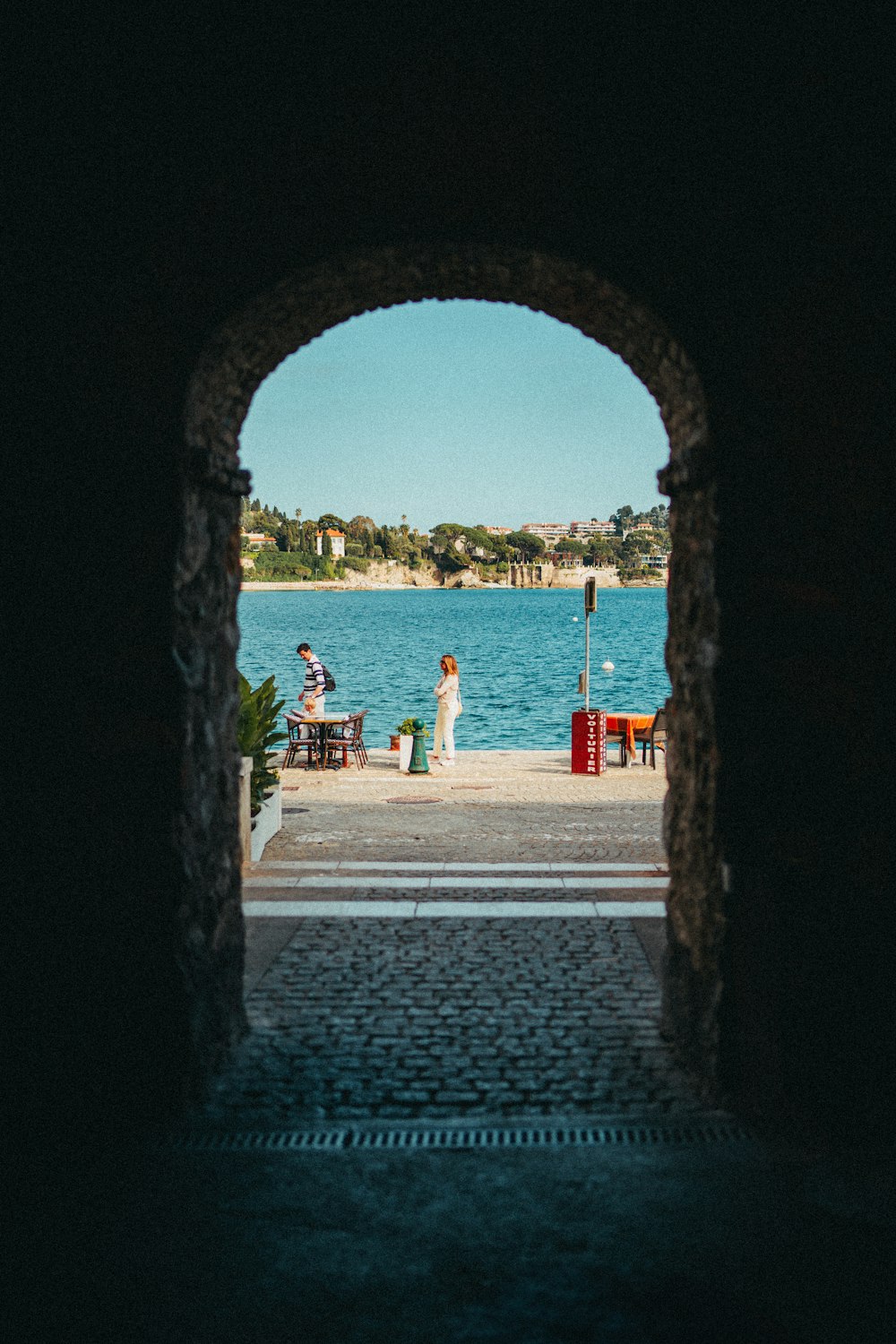 a couple of people that are standing in front of a body of water