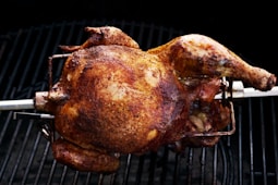 a whole chicken is cooking on a grill