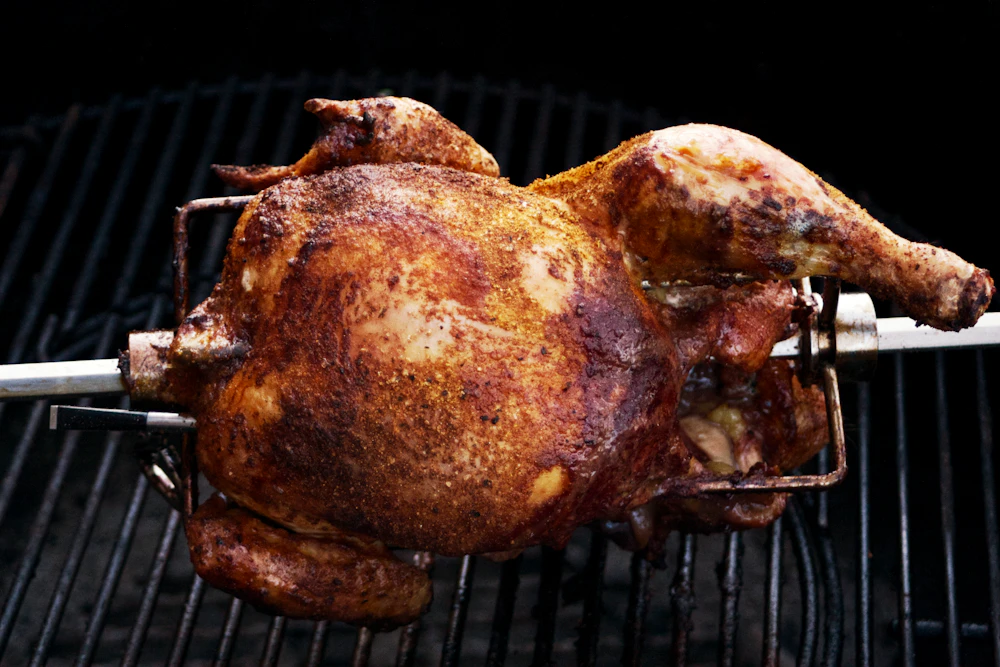 Pollo entero girando en un spiedo, dorado y recién hecho