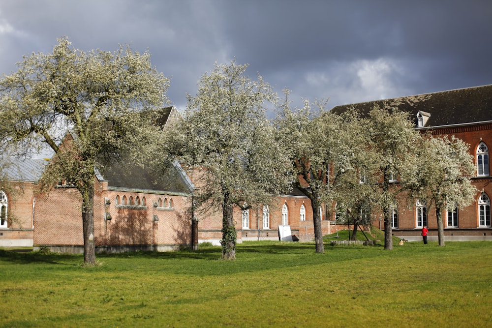 a church with trees in front of it on a cloudy day