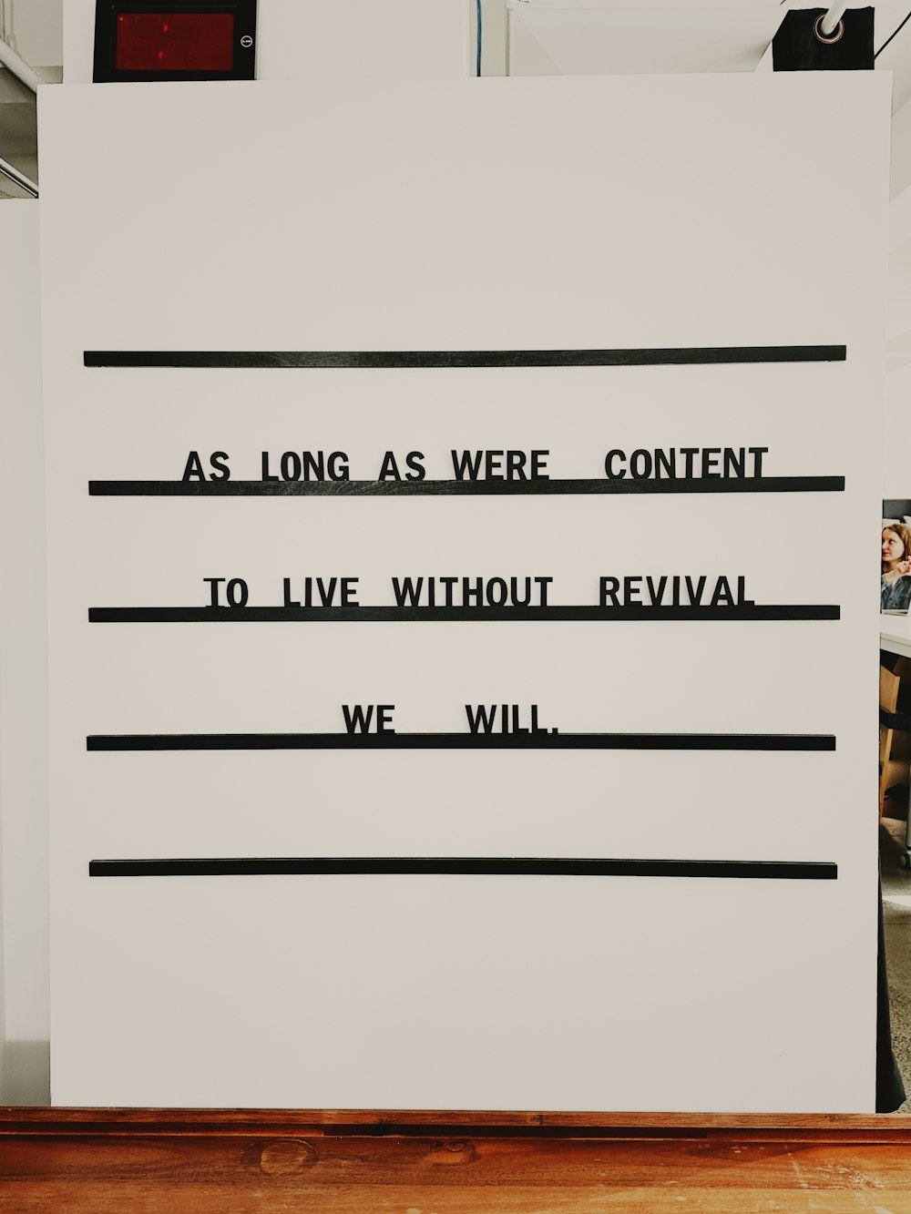 a sign on a wall that says as long as we're content to live