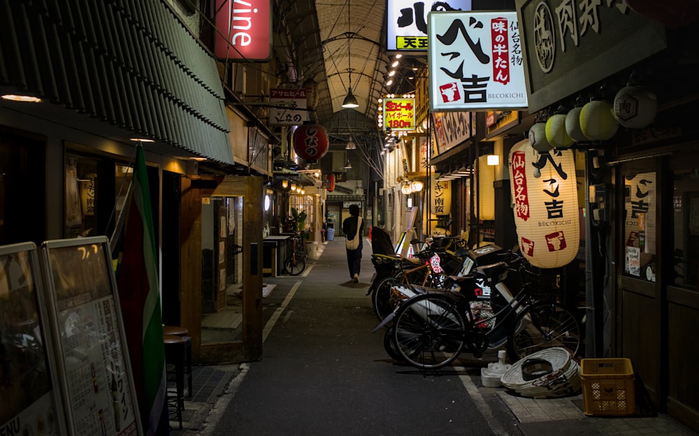a narrow alley with signs and a motorcycle parked in front of it