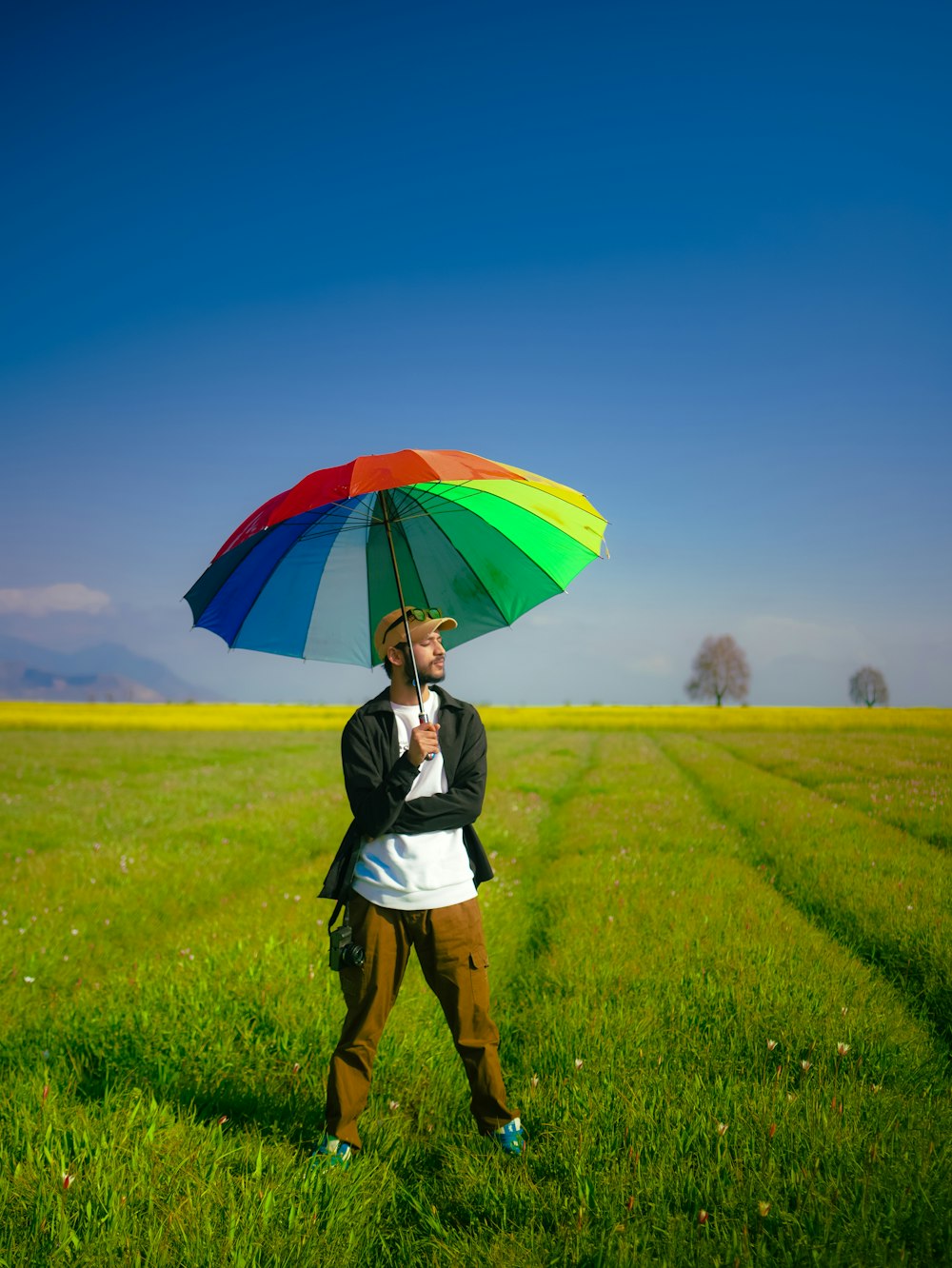 a person standing in a field holding an umbrella