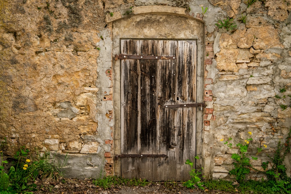 eine alte Holztür in einer Steinmauer
