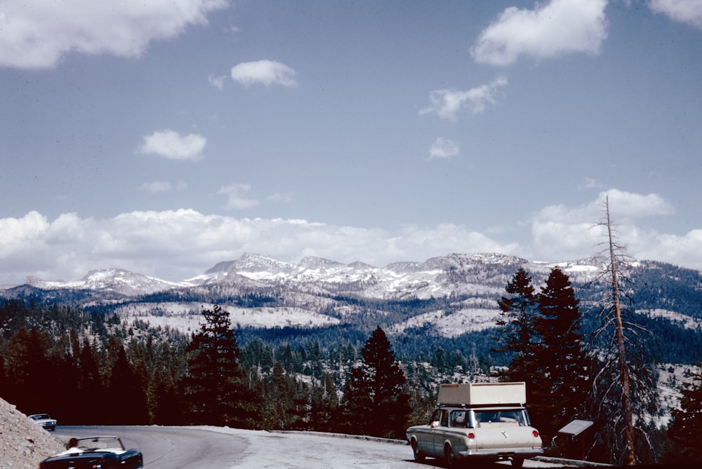 a truck parked on the side of a snow covered road