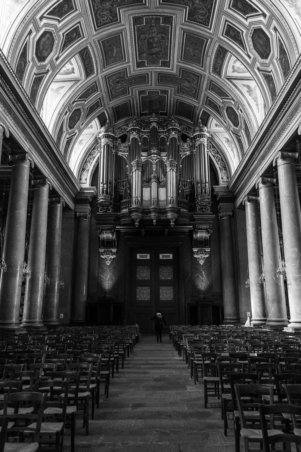 a black and white photo of a church filled with pews