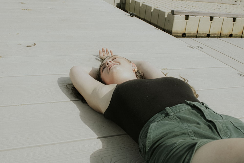 uma mulher deitada no chão de olhos fechados