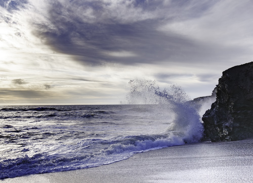 a wave crashing into the shore of a beach