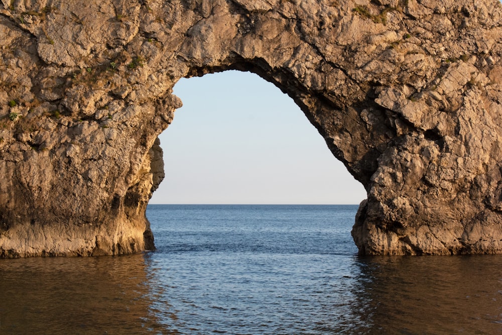 a large rock formation in the middle of a body of water