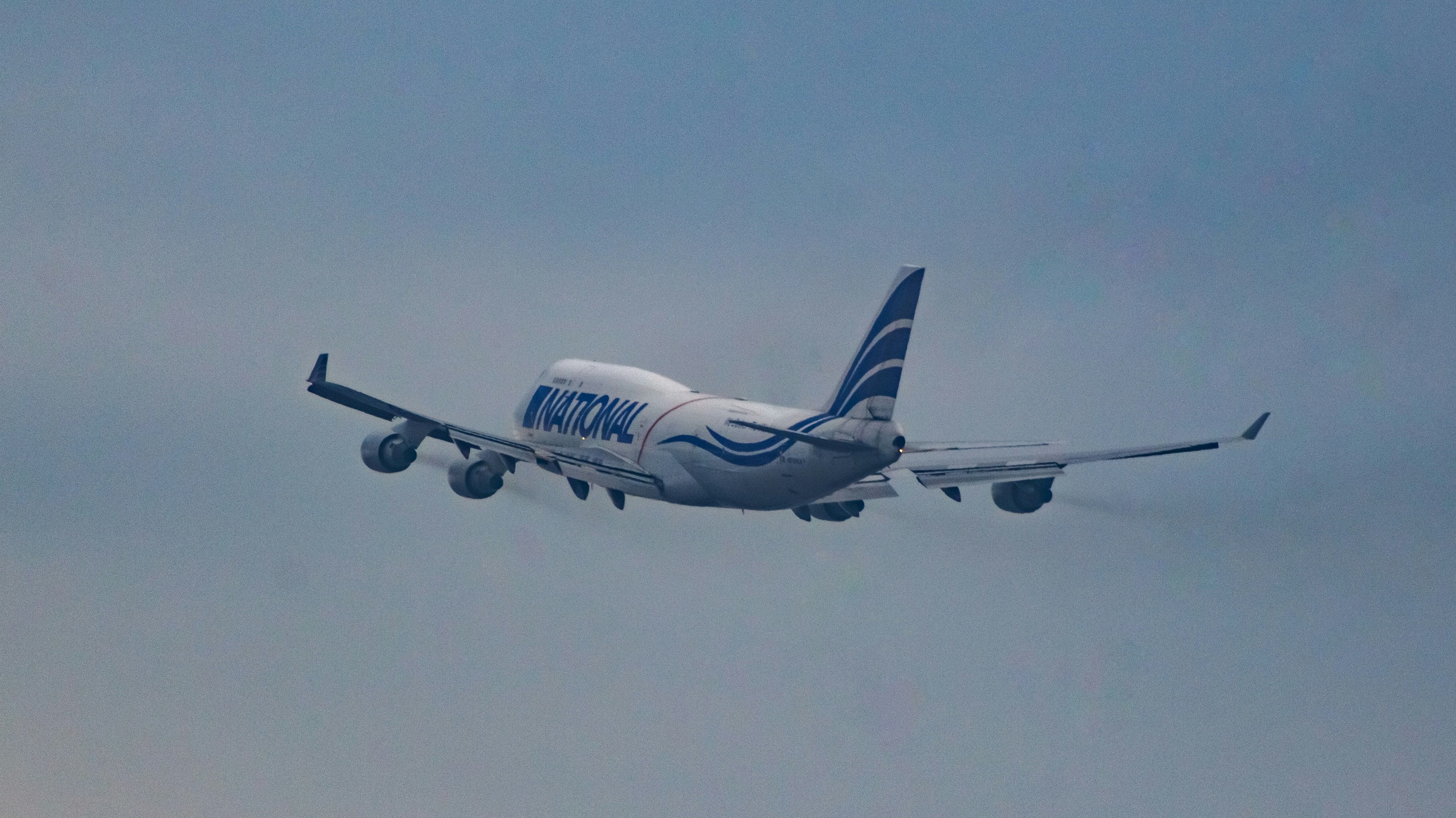 a large jetliner flying through a cloudy blue sky