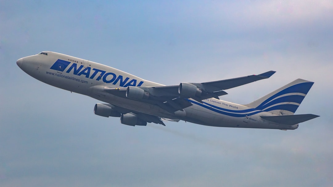 a large jetliner flying through a blue sky, National Airlines Boeing 747BCF