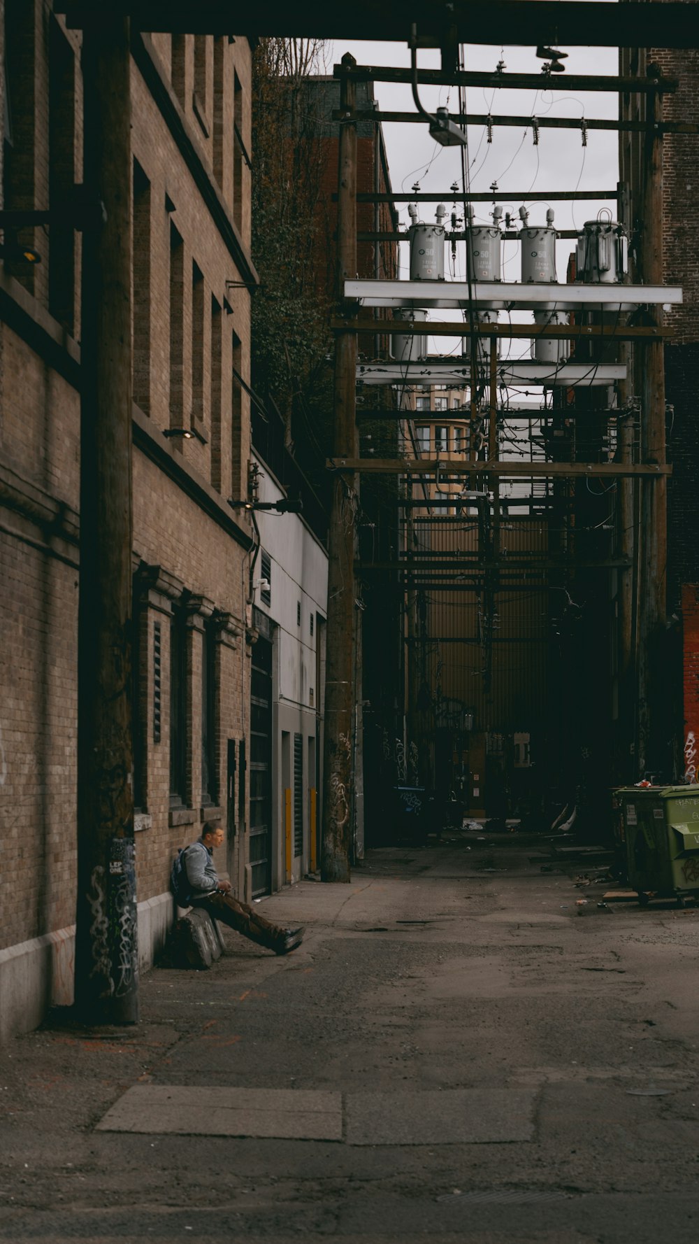 a person sitting on a bench in an alley