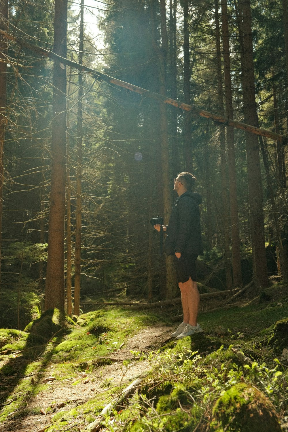 a man standing in the middle of a forest