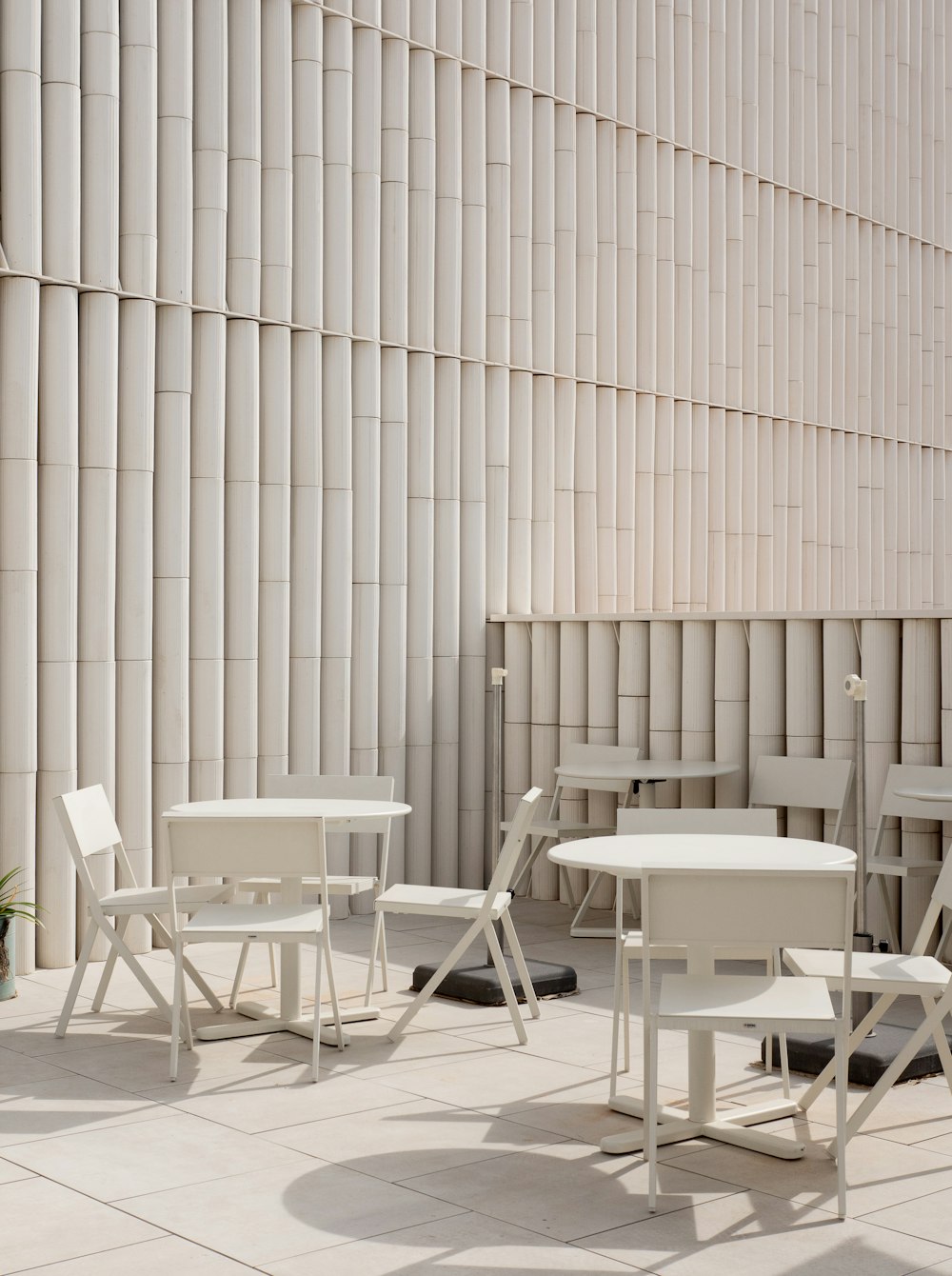 a group of white chairs and tables on a patio