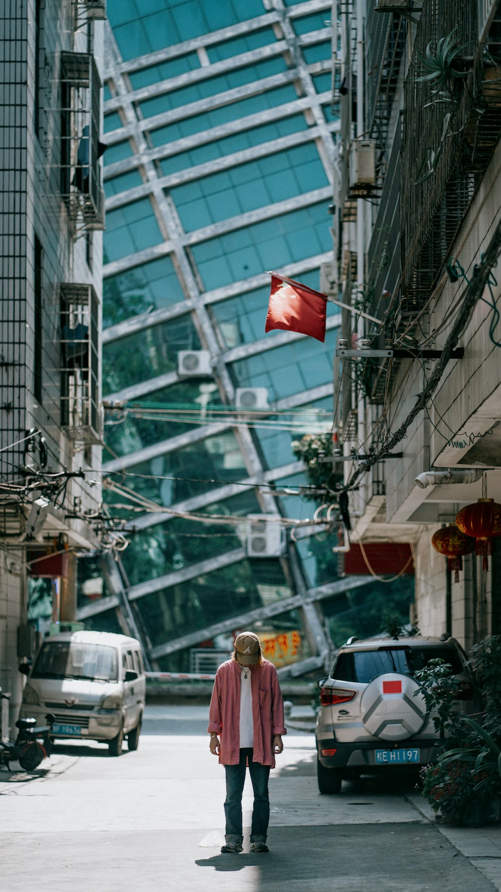 a woman walking down a street next to tall buildings
