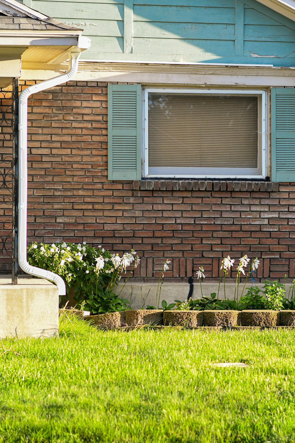 a red fire hydrant in front of a brick house