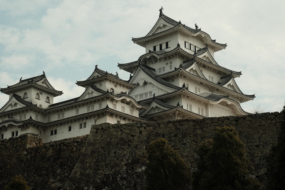 a tall white building sitting on top of a stone wall