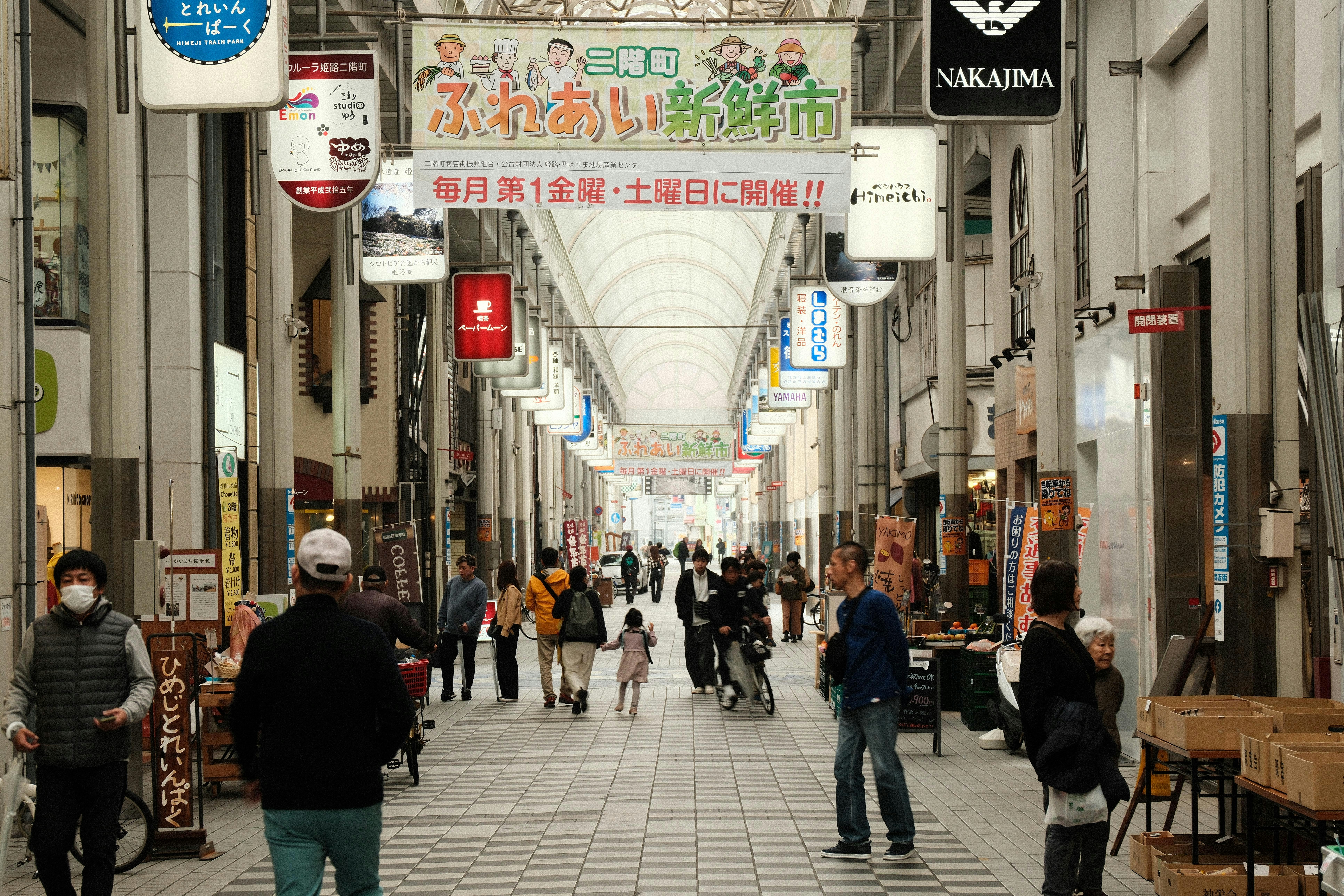 a group of people walking down a street next to tall buildings