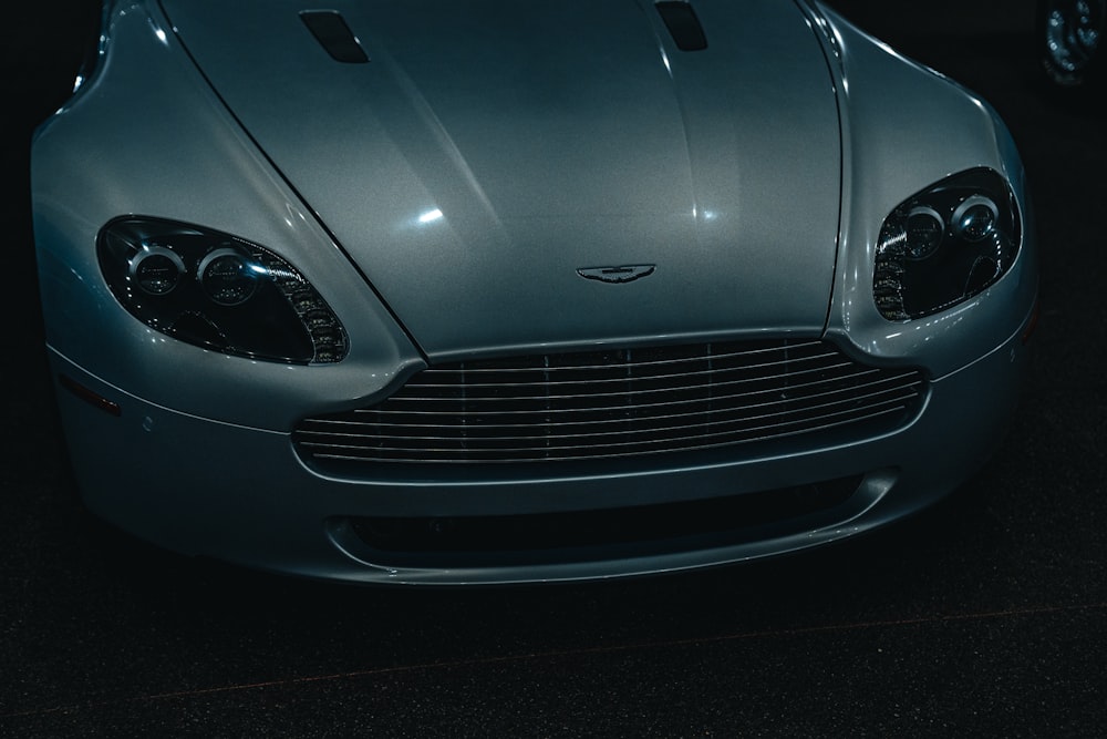 a close up of the front of a silver sports car