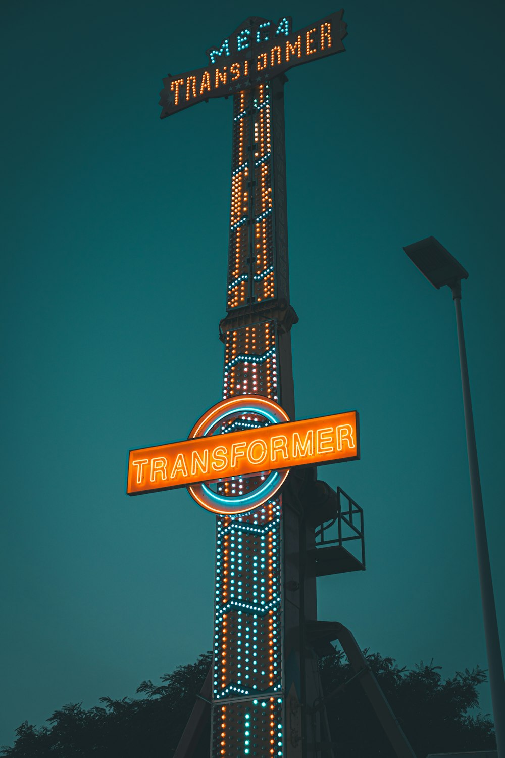 a tall tower with a neon sign on top of it