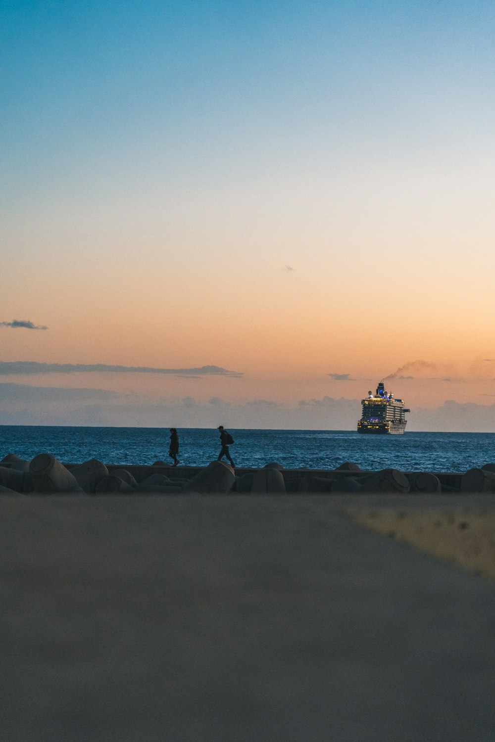 a couple of people standing on top of a sandy beach