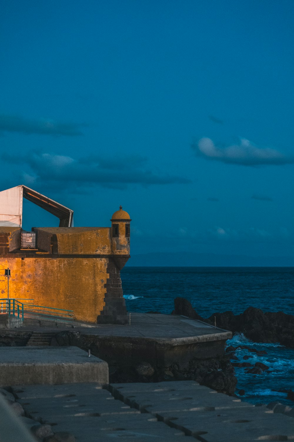 a building sitting on top of a pier next to the ocean