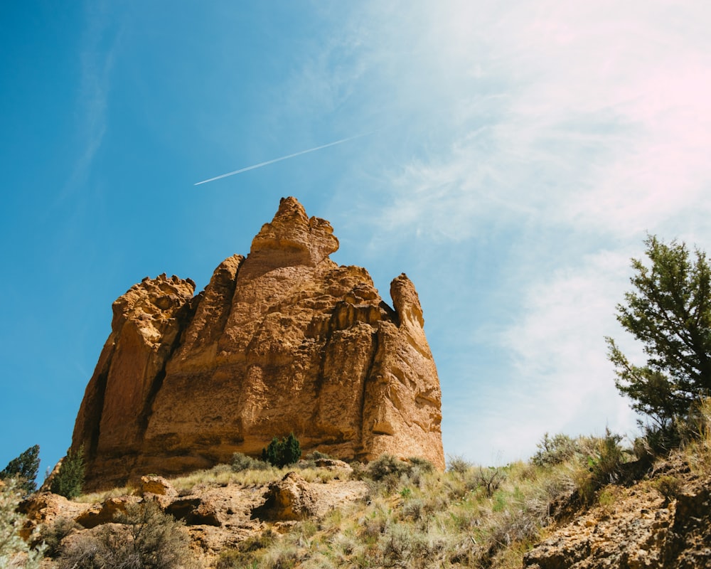 a rock formation on a hill with a clear blue sky in the background