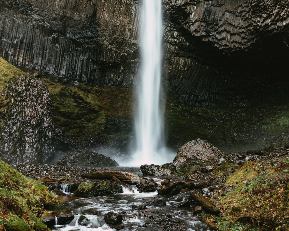 a waterfall is shown in the middle of a rocky area