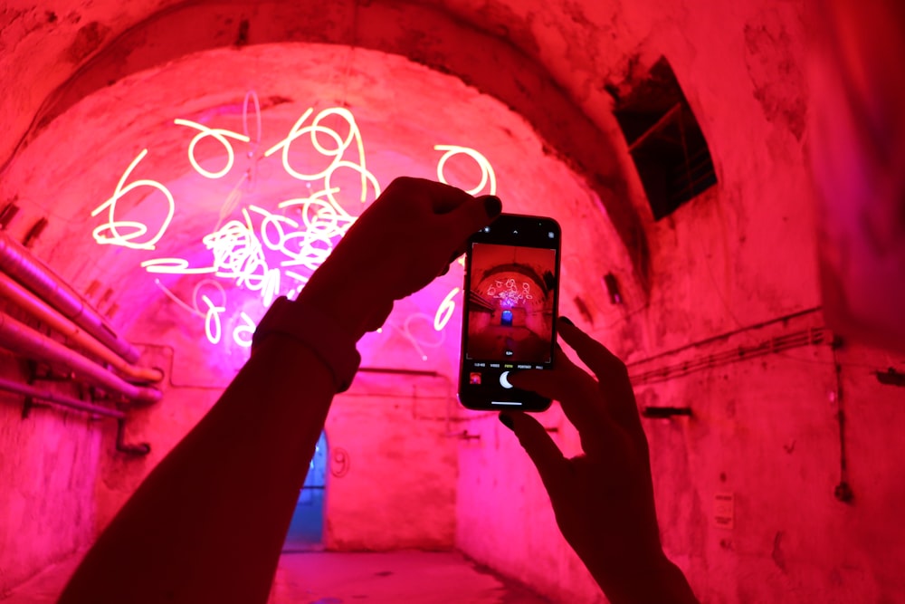 a person taking a picture of graffiti on a wall