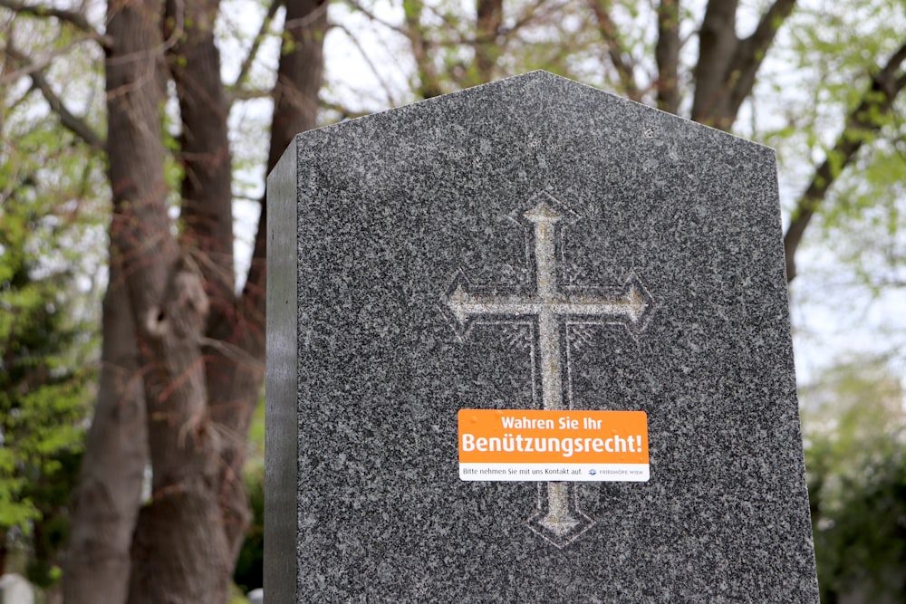 a grave with a cross and a sticker on it