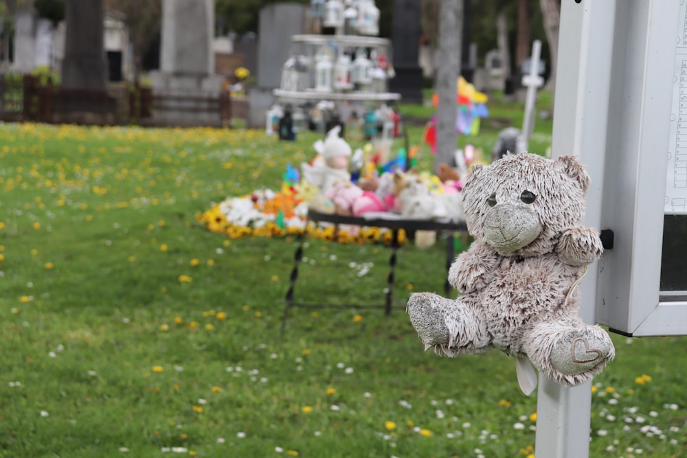 a teddy bear sitting on top of a metal pole