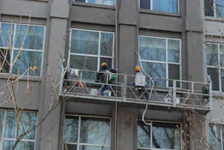 a couple of people standing on a balcony next to a tall building