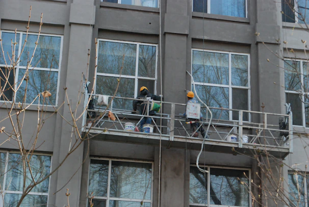 a couple of people standing on a balcony next to a tall building