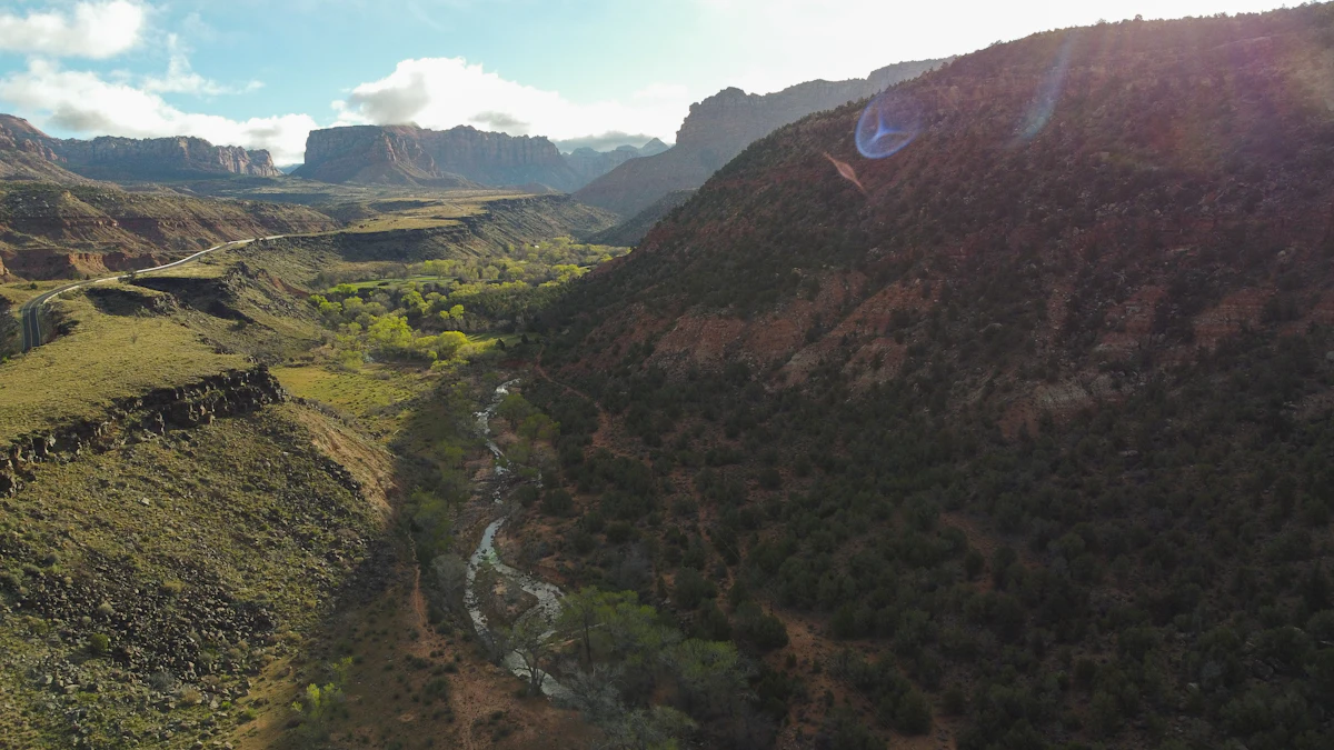 A green valley with a stream near Virgin, Utah, seen from the air, with sandstone cliffs on the skyline