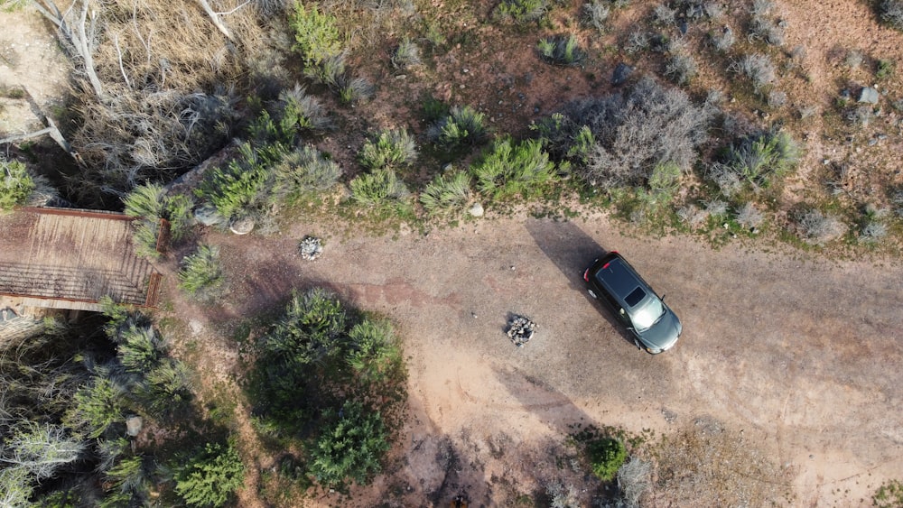 an aerial view of a car parked on a dirt road