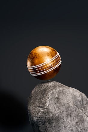a cricket ball sitting on top of a rock
