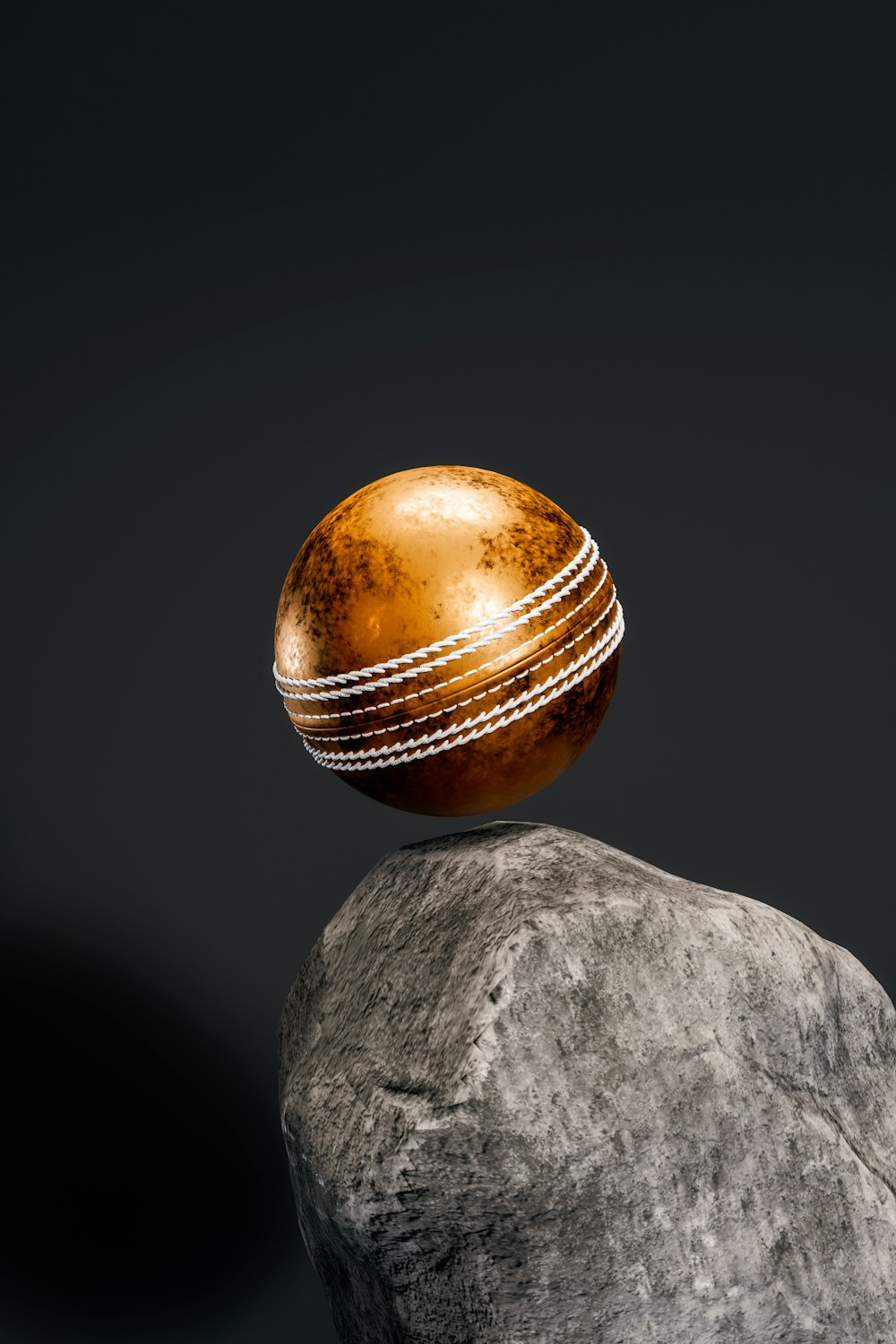 a cricket ball sitting on top of a rock