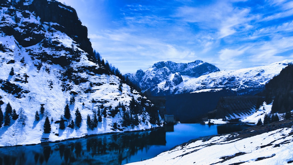 a snow covered mountain with a lake in the middle of it