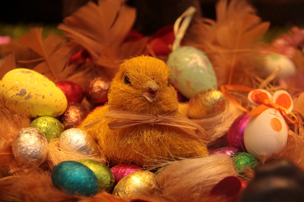 a yellow chicken sitting in a pile of eggs