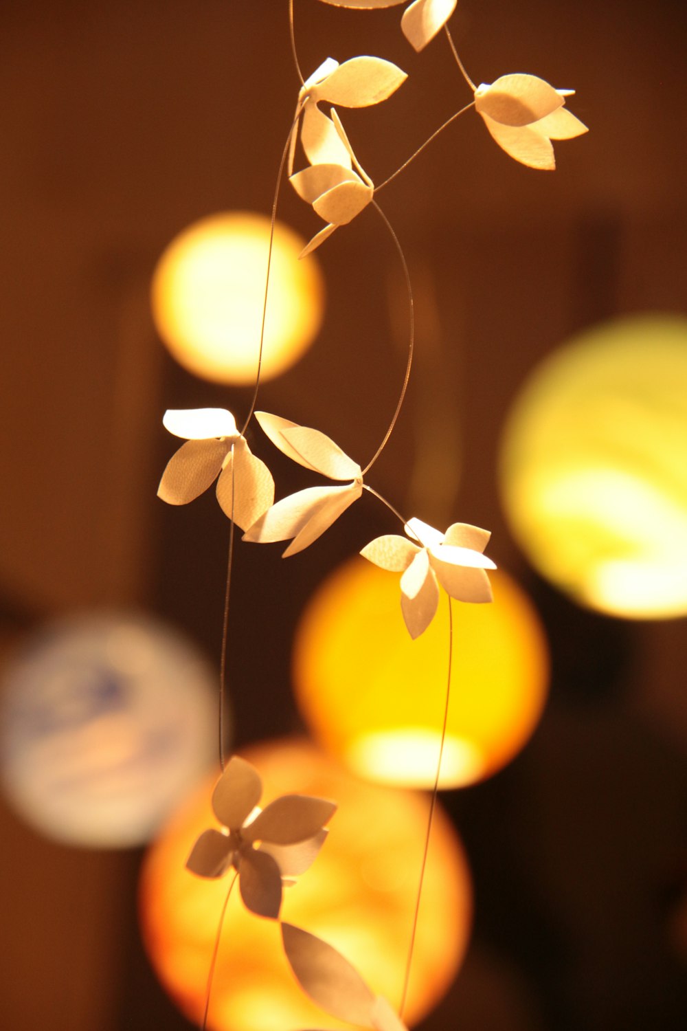 a string of paper flowers hanging from a ceiling