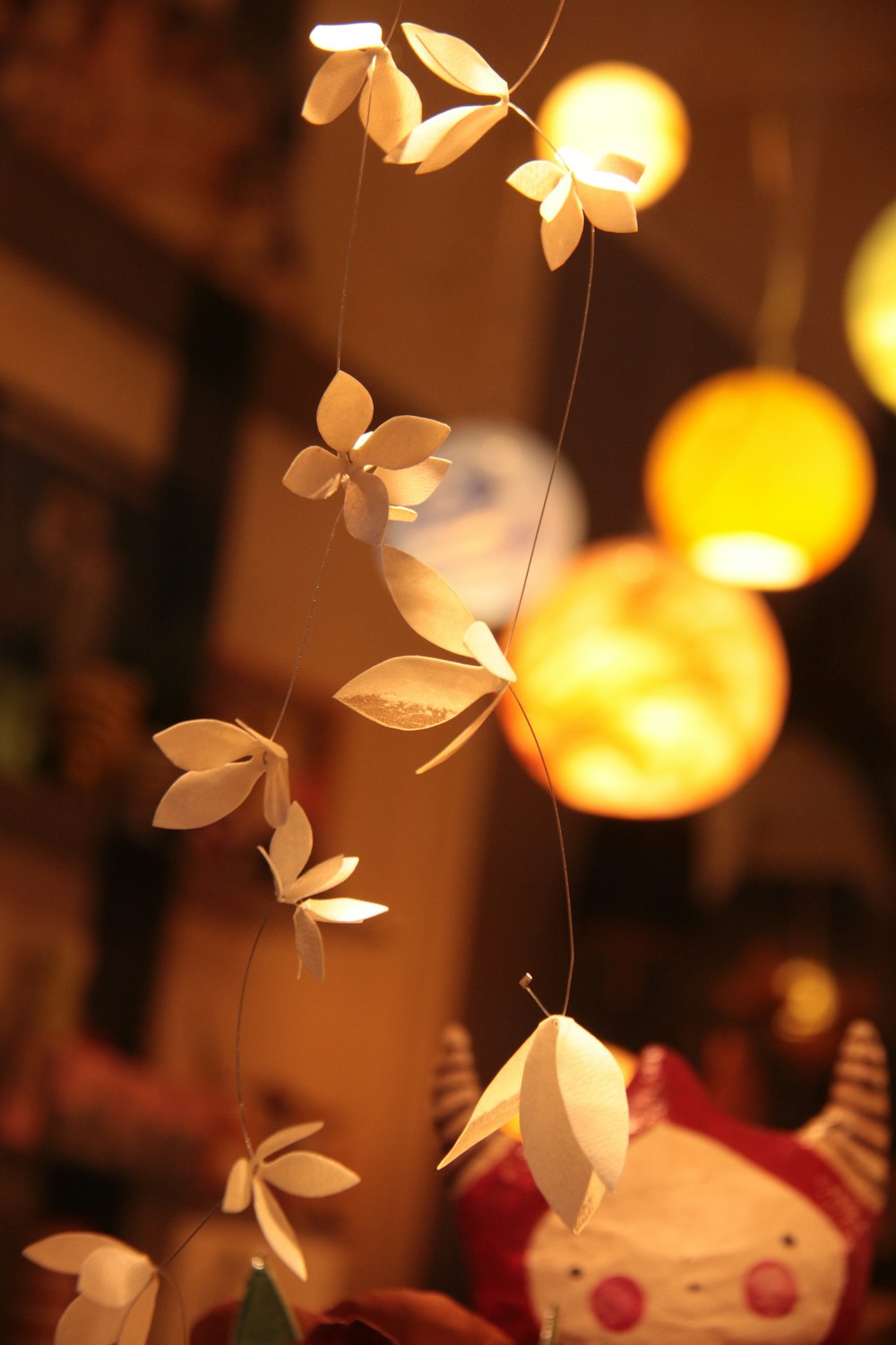 a group of paper flowers hanging from a string