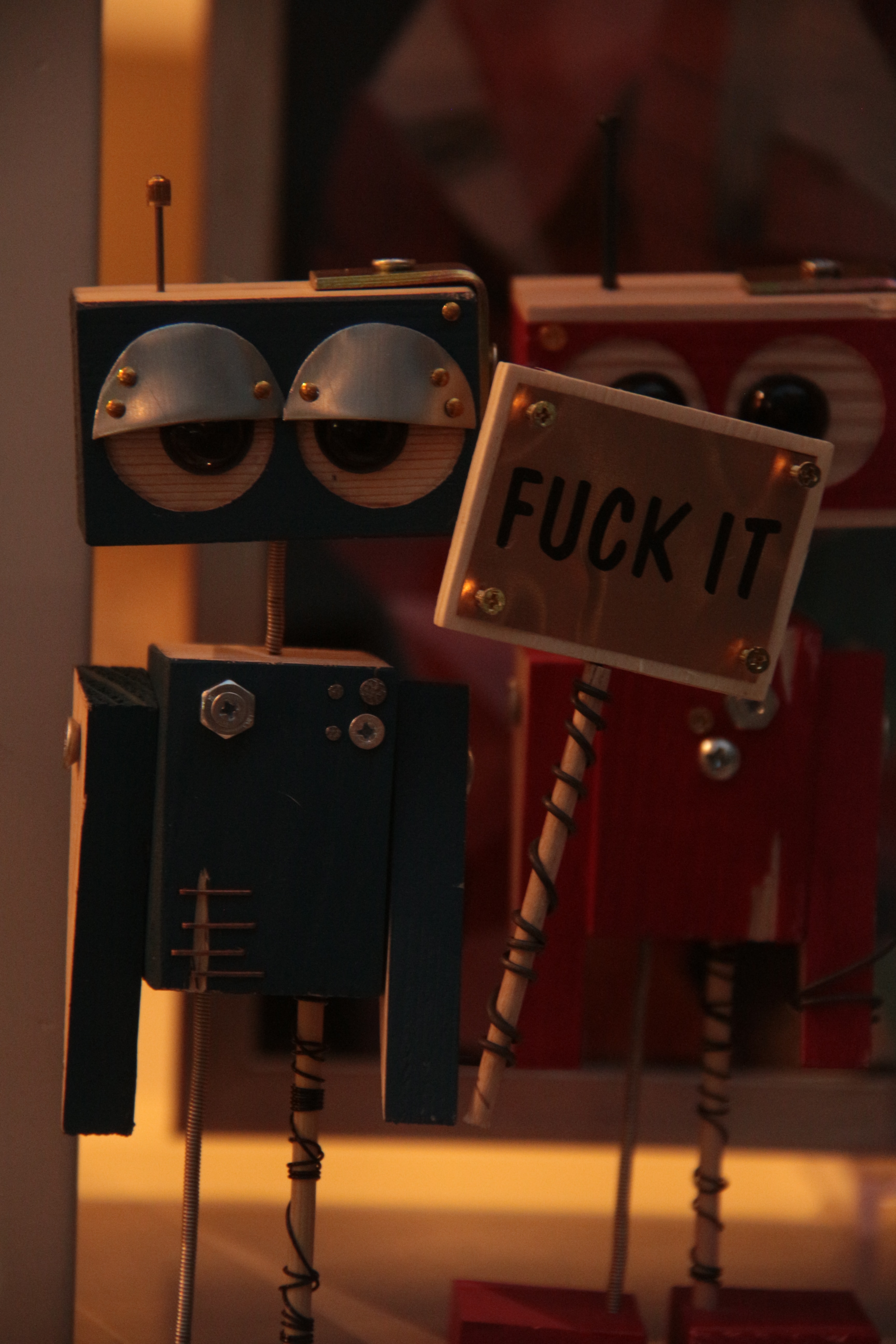 a robot holding a sign that says fuck it