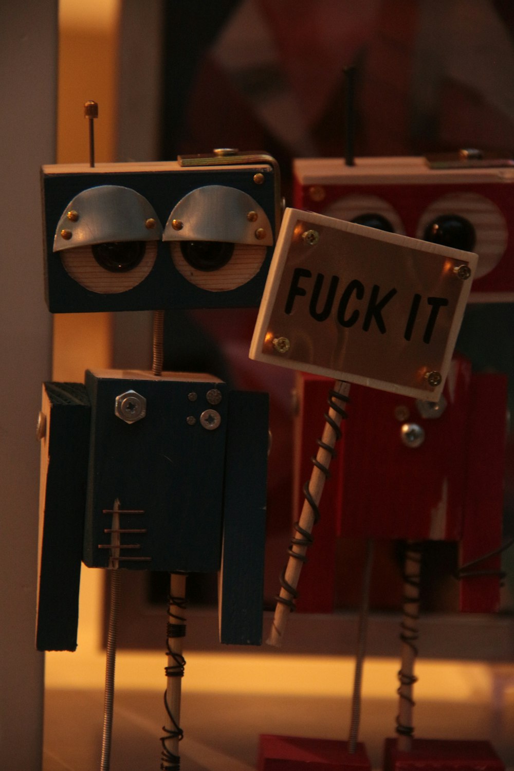 a robot holding a sign that says fuck it