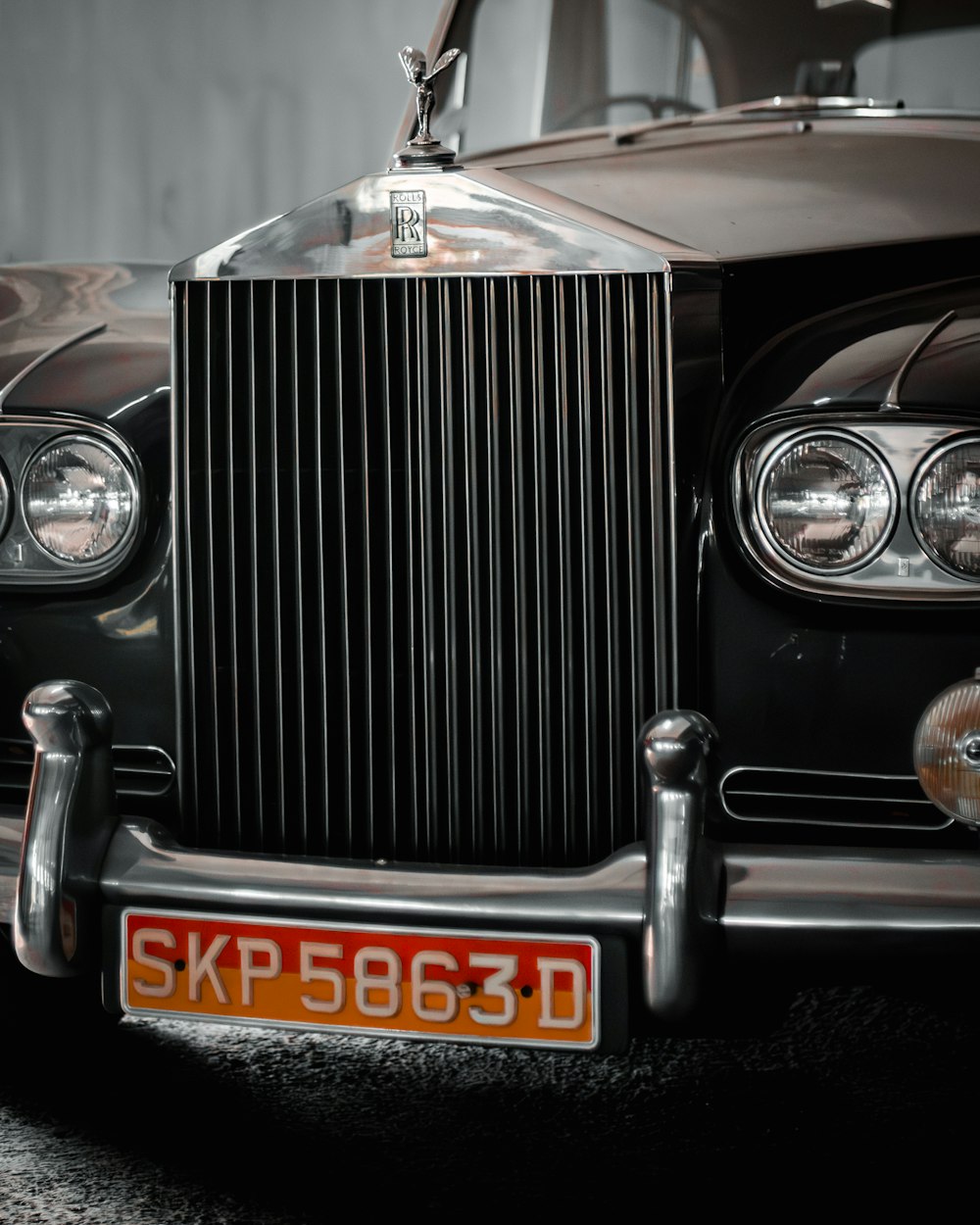 the front of an old black car with a license plate