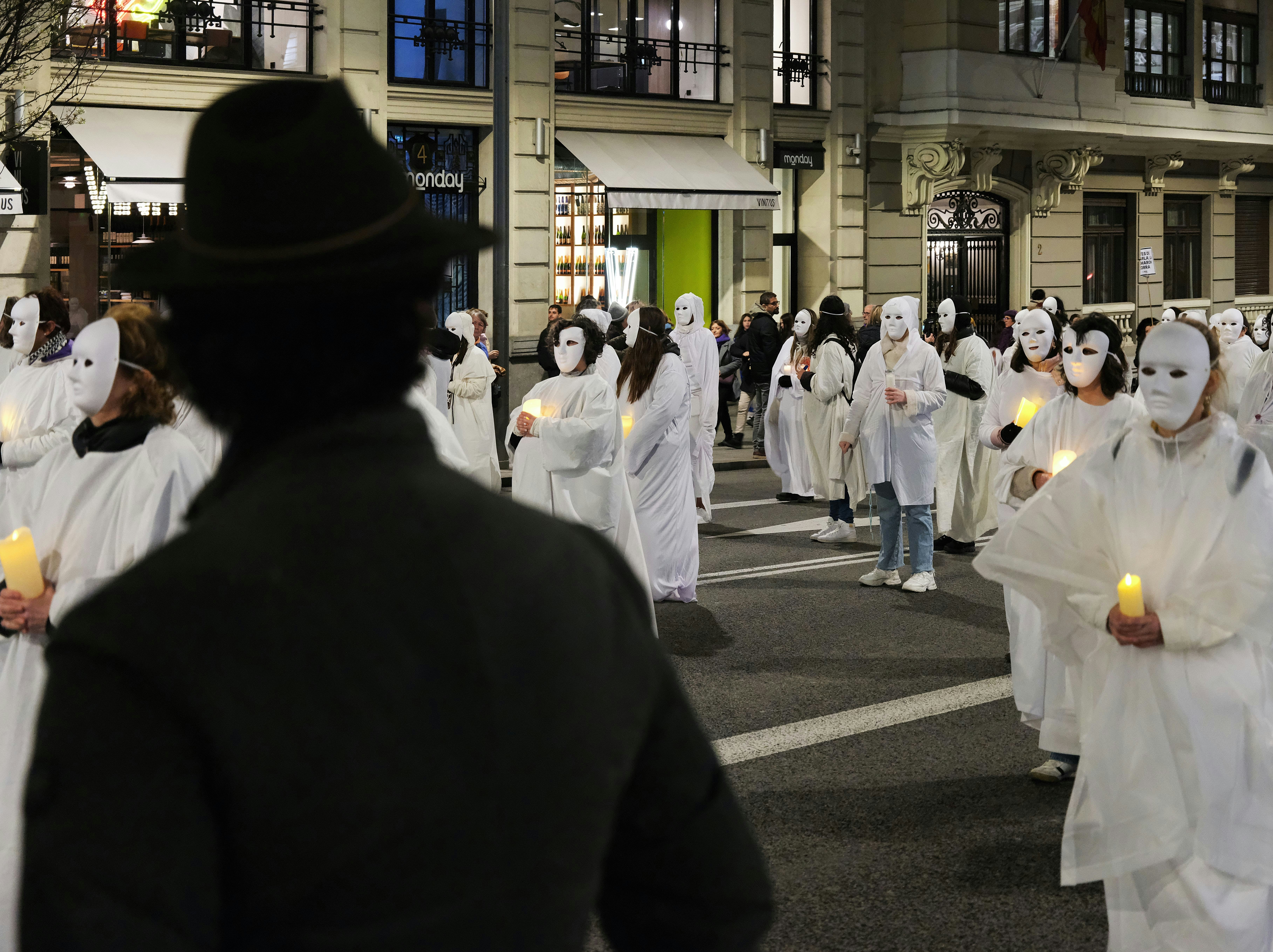 a group of people dressed in white walking down a street
