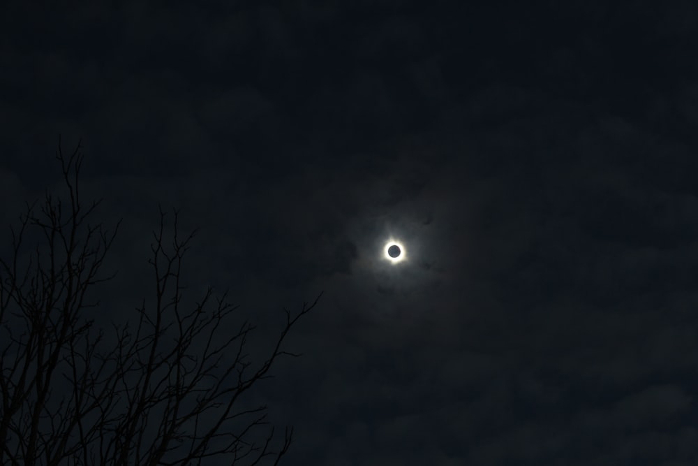 Der Mond ist durch die Wolken am Nachthimmel zu sehen