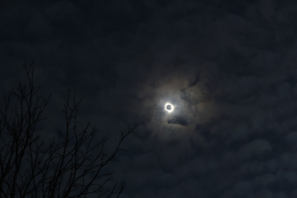 the moon is seen through the clouds in the night sky